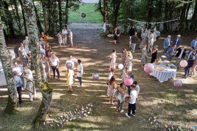 Un grand groupe de personnes souriantes levant les bras, rassemblées dans un parc pour une célébration.