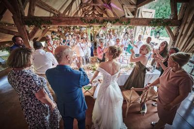 Un grand groupe de personnes souriantes levant les bras, rassemblées dans un parc pour une célébration.