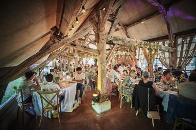 Un grand groupe de personnes souriantes levant les bras, rassemblées dans un parc pour une célébration.