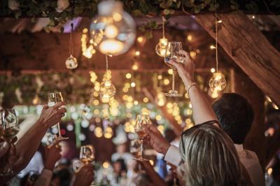 Un grand groupe de personnes souriantes levant les bras, rassemblées dans un parc pour une célébration.