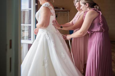 Un grand groupe de personnes souriantes levant les bras, rassemblées dans un parc pour une célébration.