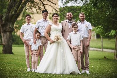 Un grand groupe de personnes souriantes levant les bras, rassemblées dans un parc pour une célébration.