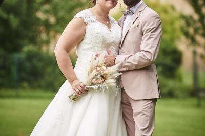 Un grand groupe de personnes souriantes levant les bras, rassemblées dans un parc pour une célébration.