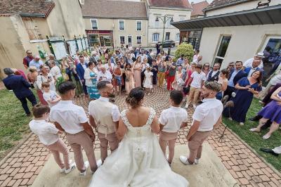 Un grand groupe de personnes souriantes levant les bras, rassemblées dans un parc pour une célébration.