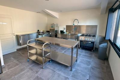 Miniature Location salle Civray (Vienne) - Gîte Montplaisir #10 Lavabo avec miroir éclairé, distributeur de savon et essuie-mains, adjacent à une cloison séparant un urinoir.