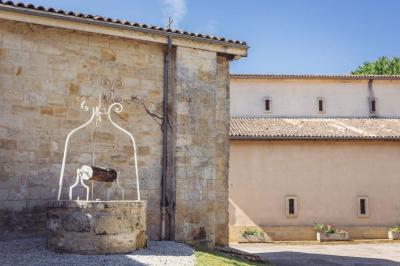Vue d'un village rural avec une église en pierre entourée de champs verdoyants sous un ciel dégagé.
