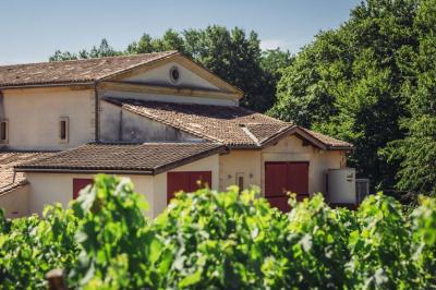 Vue d'un village rural avec une église en pierre entourée de champs verdoyants sous un ciel dégagé.