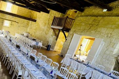 Vue d'un village rural avec une église en pierre entourée de champs verdoyants sous un ciel dégagé.