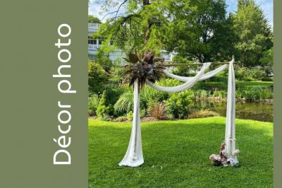 Arrangement floral avec des fleurs roses et blanches, entouré de petits sachets cadeaux en tissu et jute sur une table.