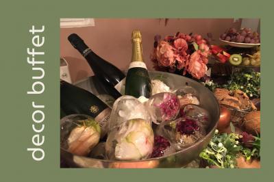 Arrangement floral avec des fleurs roses et blanches, entouré de petits sachets cadeaux en tissu et jute sur une table.