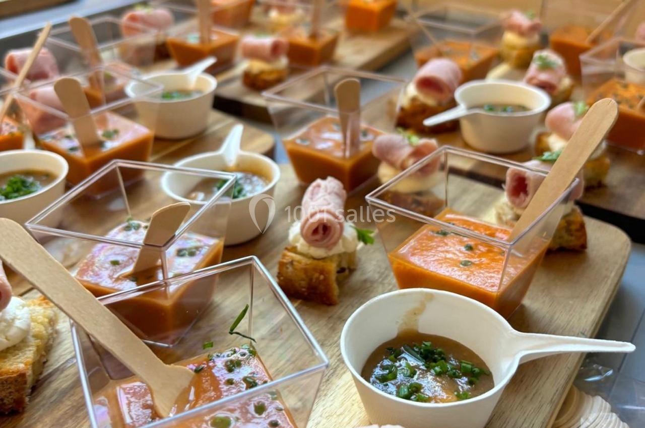 Assortiment de verrines et bouchées apéritives présentées sur des plateaux en bois.