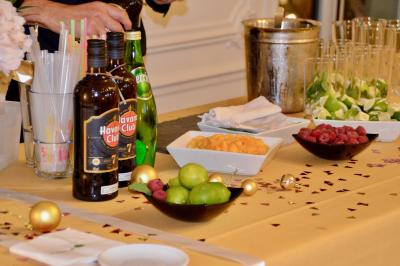 Façade illuminée d'un bâtiment élégant au crépuscule, avec un jardin et des invités rassemblés devant.