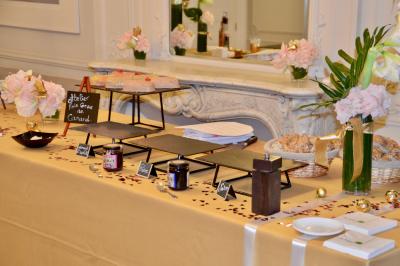 Façade illuminée d'un bâtiment élégant au crépuscule, avec un jardin et des invités rassemblés devant.