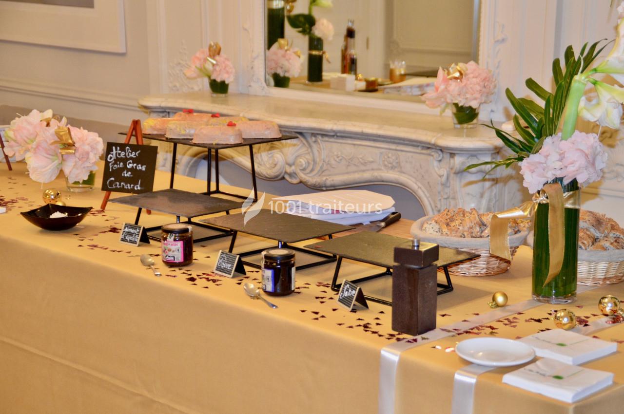 Table de buffet élégante avec foie gras, confitures, pain et décorations florales dans une ambiance raffinée.