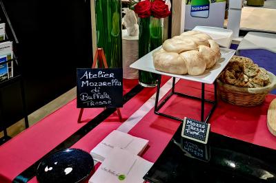 Façade illuminée d'un bâtiment élégant au crépuscule, avec un jardin et des invités rassemblés devant.