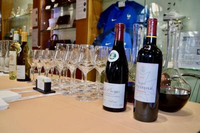 Façade illuminée d'un bâtiment élégant au crépuscule, avec un jardin et des invités rassemblés devant.