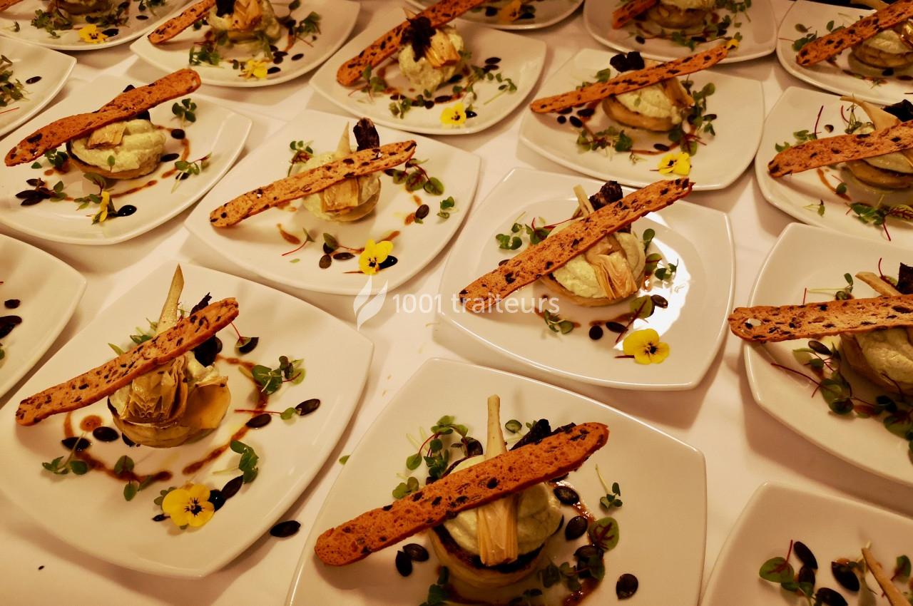 Assiettes dressées avec des entrées composées de légumes, herbes, fleurs comestibles et fines tranches de pain.