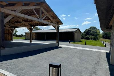 Chambre mansardée avec mur en briques, lit avec coussins, parquet clair et lumière naturelle provenant de deux fenêtres de…