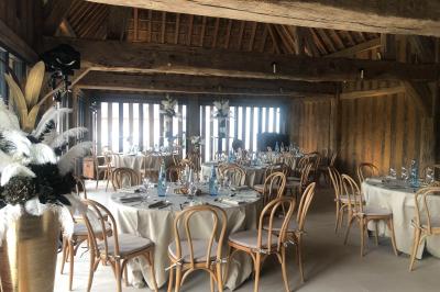 Chambre mansardée avec mur en briques, lit avec coussins, parquet clair et lumière naturelle provenant de deux fenêtres de…