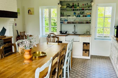 Miniature Gite La Ferme Chambre mansardée avec mur en briques, lit avec coussins, parquet clair et lumière naturelle provenant de deux fenêtres de…