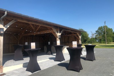 Chambre mansardée avec mur en briques, lit avec coussins, parquet clair et lumière naturelle provenant de deux fenêtres de…