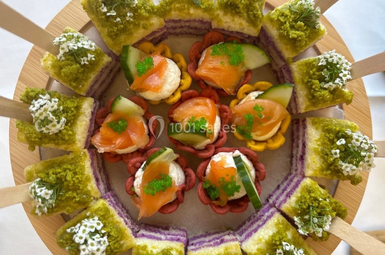Plateau de bouchées apéritives colorées avec saumon, concombre, œufs de poisson et toasts garnis de mousse verte.