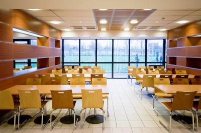 Douche accessible avec barre d'appui, siège rabattable et pommeau de douche réglable.