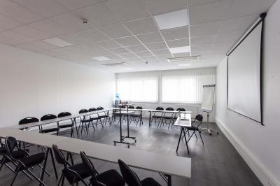 Douche accessible avec barre d'appui, siège rabattable et pommeau de douche réglable.