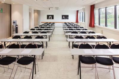 Douche accessible avec barre d'appui, siège rabattable et pommeau de douche réglable.