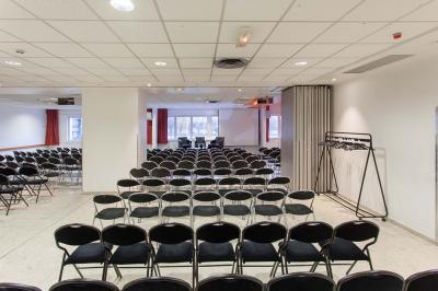 Douche accessible avec barre d'appui, siège rabattable et pommeau de douche réglable.