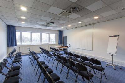 Douche accessible avec barre d'appui, siège rabattable et pommeau de douche réglable.