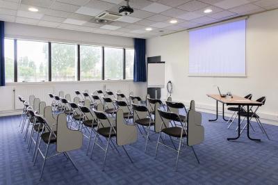 Douche accessible avec barre d'appui, siège rabattable et pommeau de douche réglable.