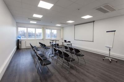 Douche accessible avec barre d'appui, siège rabattable et pommeau de douche réglable.