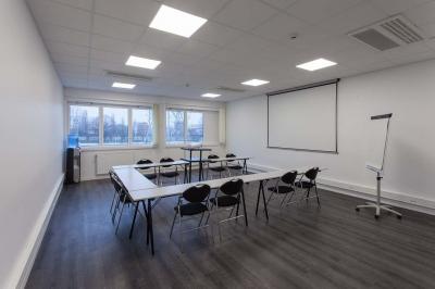 Douche accessible avec barre d'appui, siège rabattable et pommeau de douche réglable.