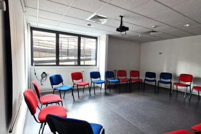 Douche accessible avec barre d'appui, siège rabattable et pommeau de douche réglable.