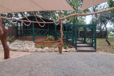 Terrain de pétanque en terre battue entouré d'arbres dans un espace naturel.