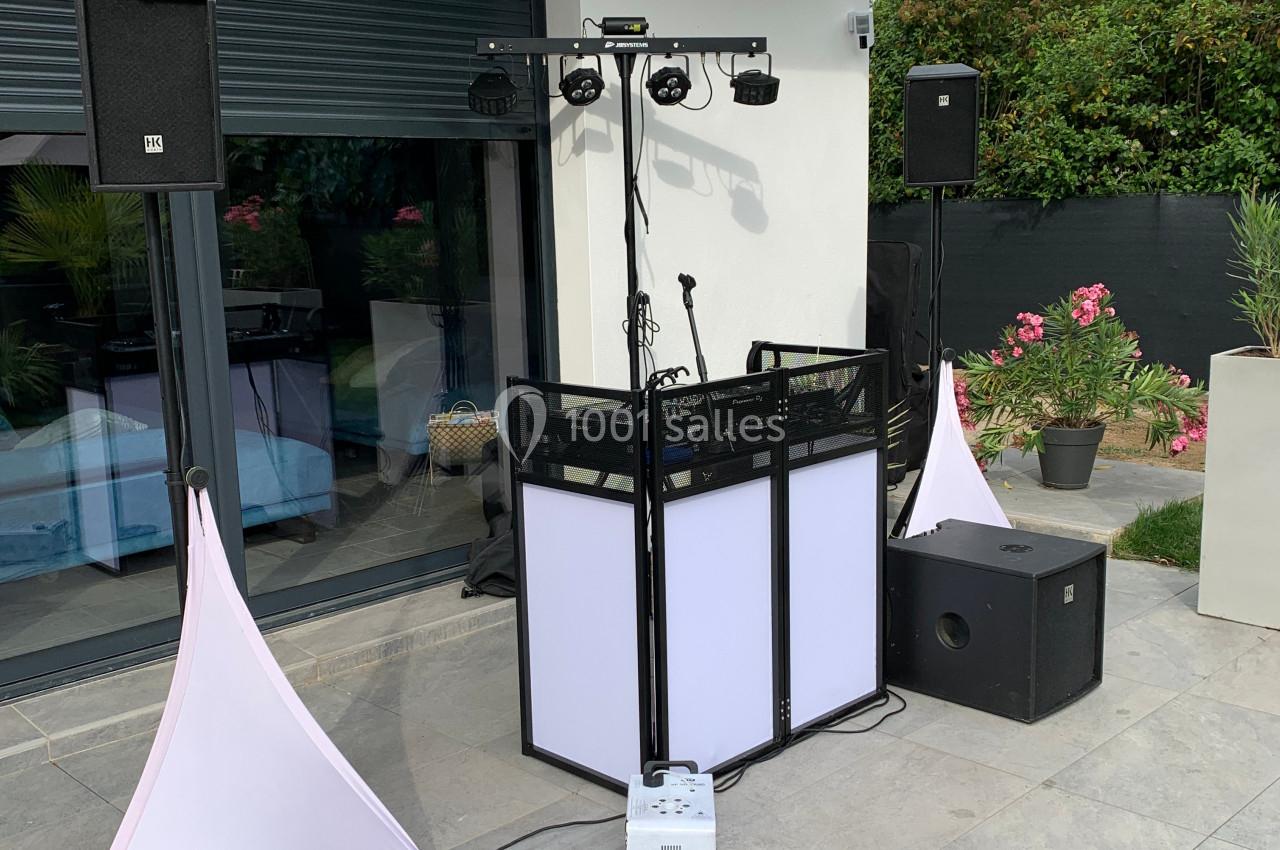 Équipement de sonorisation et éclairage installé en extérieur devant une baie vitrée, prêt pour un événement.