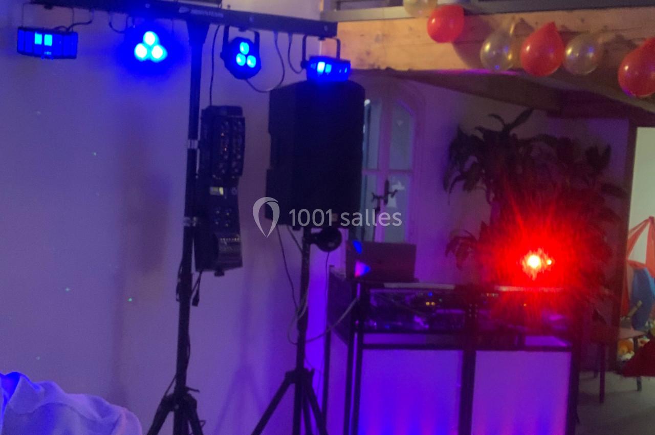 Équipement de sonorisation et éclairage avec projecteurs colorés dans une salle décorée de ballons.