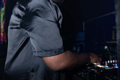 Entrée d'un club nocturne avec enseigne lumineuse ’Infinity Club’ et porte ornée de motifs décoratifs.