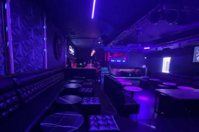 Façade d'un club nocturne avec enseigne lumineuse ’Infinity Club’ et porte ornée de motifs décoratifs.