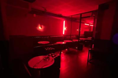 Façade d'un club nocturne avec enseigne lumineuse ’Infinity Club’ et porte ornée de motifs décoratifs.