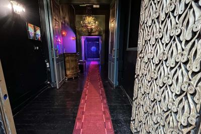 Façade d'un club nocturne avec enseigne lumineuse ’Infinity Club’ et porte ornée de motifs décoratifs.