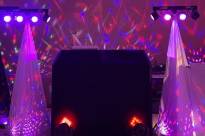 Un homme en costume bleu tient un saxophone dans un intérieur lumineux avec de grandes fenêtres.