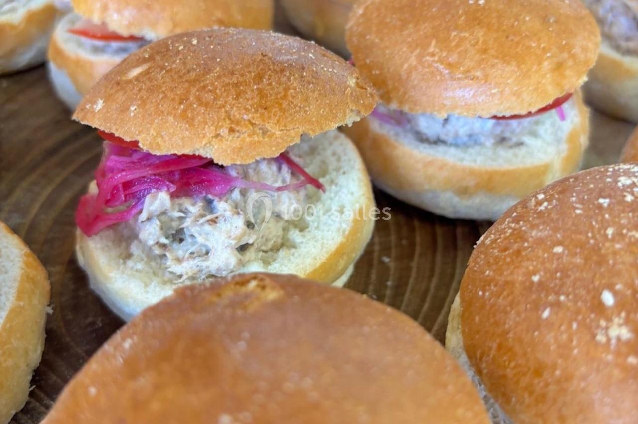 Petits sandwichs garnis de rillettes et d'oignons rouges marinés, présentés sur une surface en bois.