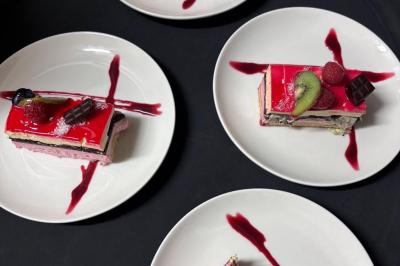 Une assiette contenant une préparation de poisson effiloché avec des herbes, accompagnée de trois points de purée verte.