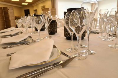 Salle décorée avec des ballons roses, éclairage violet, deux personnes marchant au centre, tables hautes et chaises…