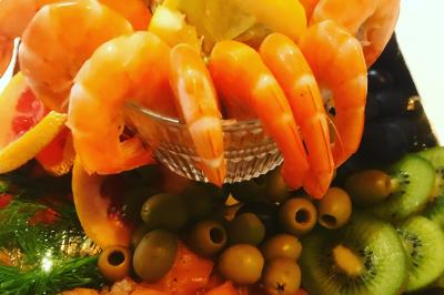 Baby-foot géant installé dans un espace intérieur avec éclairage tamisé et tables hautes en arrière-plan.