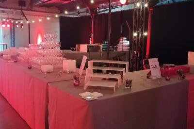 Baby-foot géant installé dans un espace intérieur avec éclairage tamisé et tables hautes en arrière-plan.