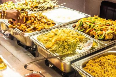 Baby-foot géant installé dans un espace intérieur avec éclairage tamisé et tables hautes en arrière-plan.