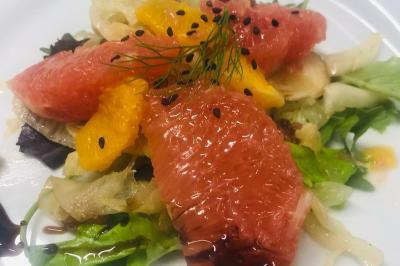 Baby-foot géant installé dans un espace intérieur avec éclairage tamisé et tables hautes en arrière-plan.